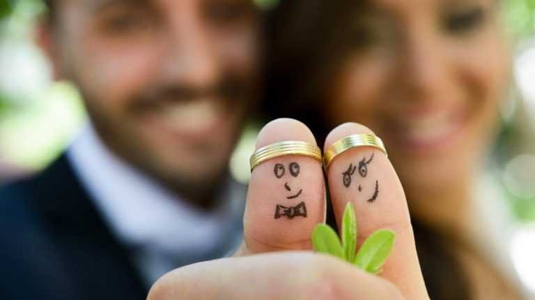wedding rings on their fingers painted with the bride and groom